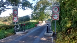 Flanchford Road bridge over the River Mole was substantially damaged by floods in 2014 and awaits permanent repair. In the meantime the downstream side is cordoned off by barriers and a weight and width limit has been imposed.